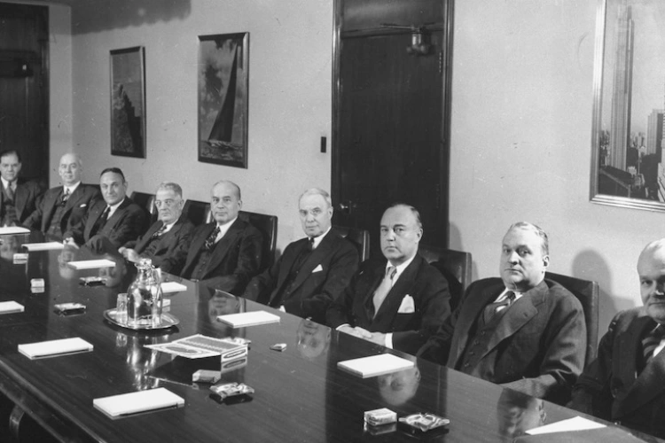 Black and white photo of white men around a boardroom table - not diverse, showing there is much privilege in leadership