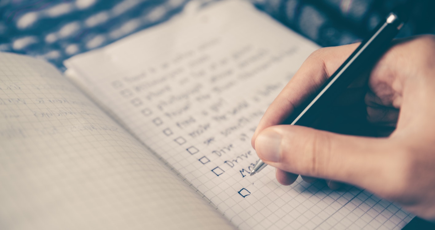 person making a list with pen and notebook, to help with business planning - making a plan B