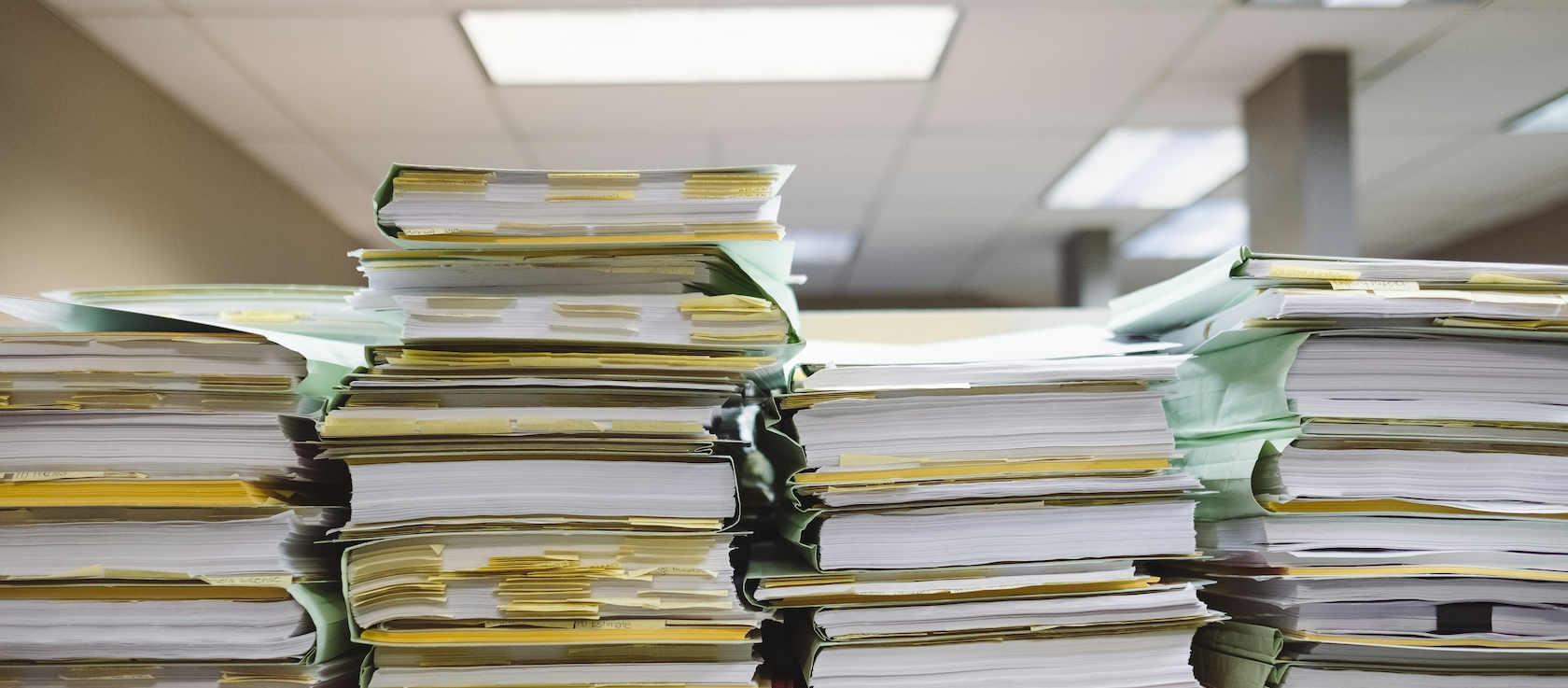 Image of piles of paperwork in an office. The article is about tendering and how small businesses can work with government.